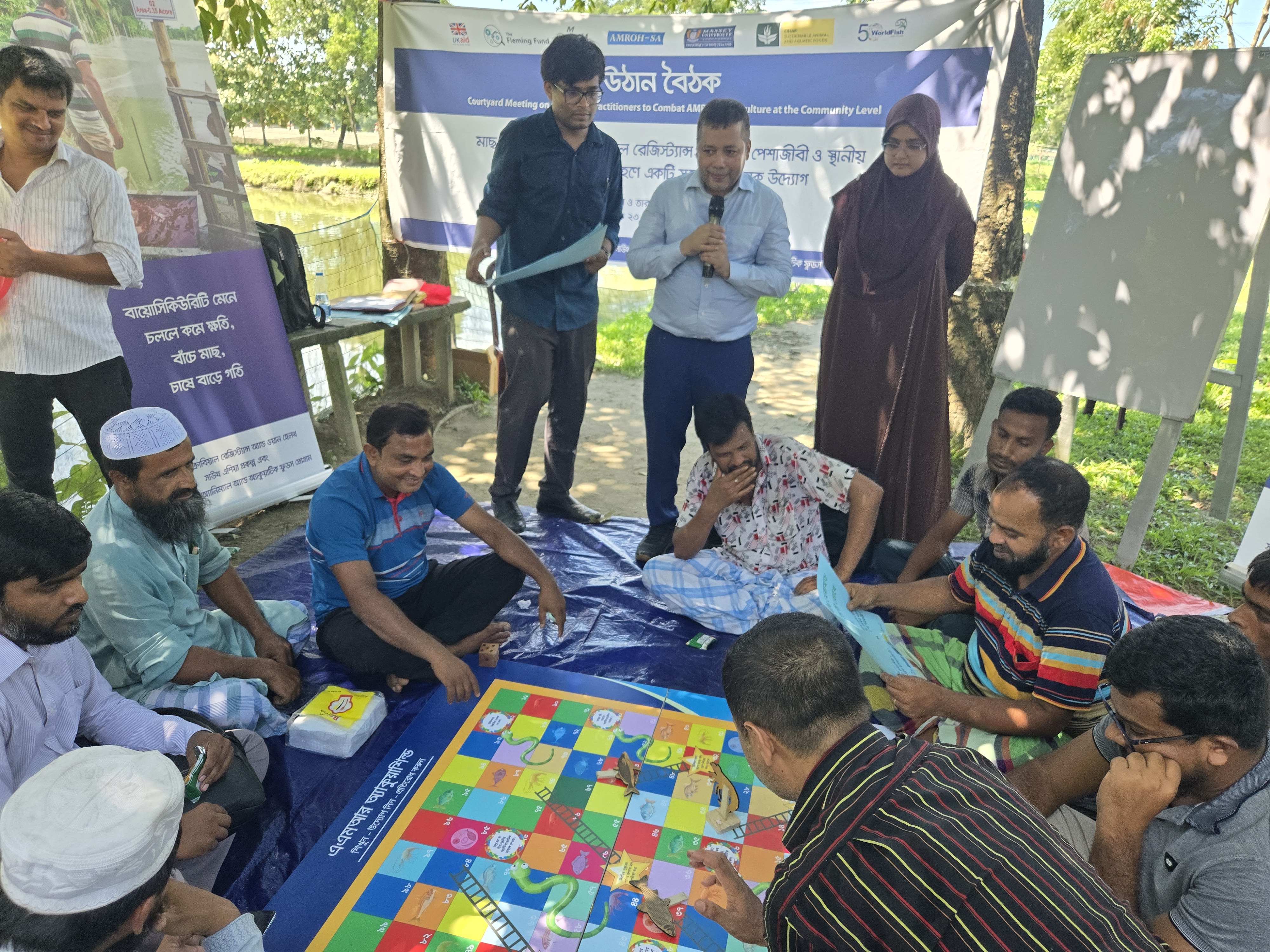 Facilitators are facilitating the AquaShield snakes and ladders learning game. Photo: K.M. Shkhawat Hossen.  