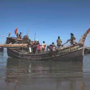 Caption: Fishers are preparing their boat at Najirar Tek, Cox's Bazar. This is soon after the government-mandated fishing ban ends, and they resume their livelihoods. Credit: Hamid Hossen 