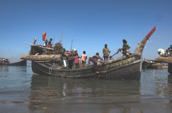 Caption: Fishers are preparing their boat at Najirar Tek, Cox's Bazar. This is soon after the government-mandated fishing ban ends, and they resume their livelihoods. Credit: Hamid Hossen 