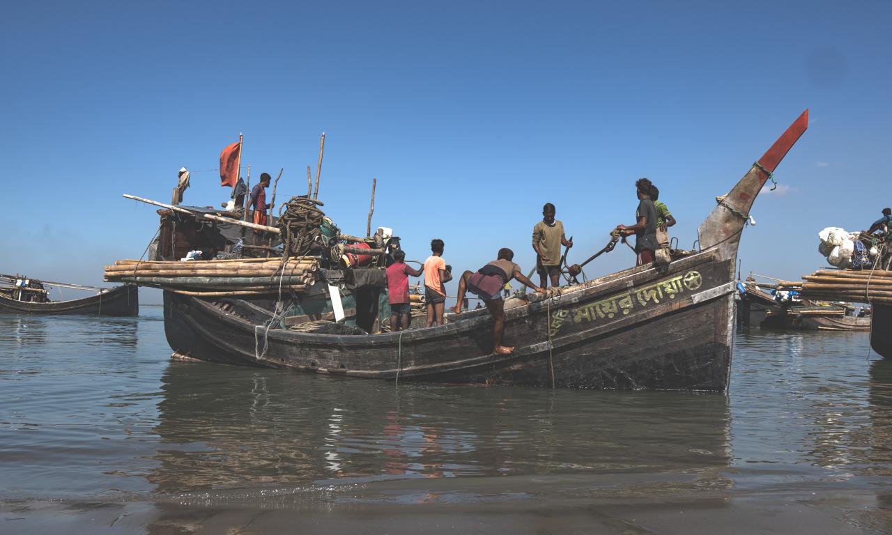 Caption: Fishers are preparing their boat at Najirar Tek, Cox's Bazar. This is soon after the government-mandated fishing ban ends, and they resume their livelihoods. Credit: Hamid Hossen 